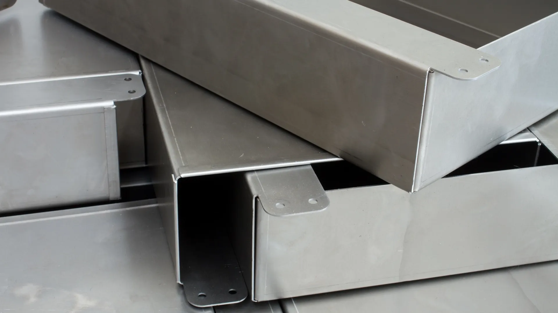 Close-up of nested stainless steel enclosure boxes with laser-cut mounting tabs
