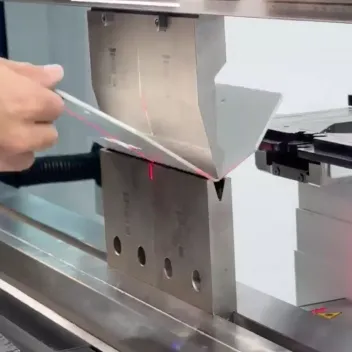Operator aligning a sheet metal blank on a press brake before a bend