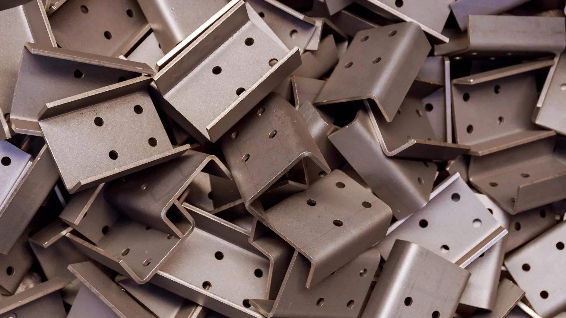 Pile of formed sheet metal Z-brackets with punched mounting holes