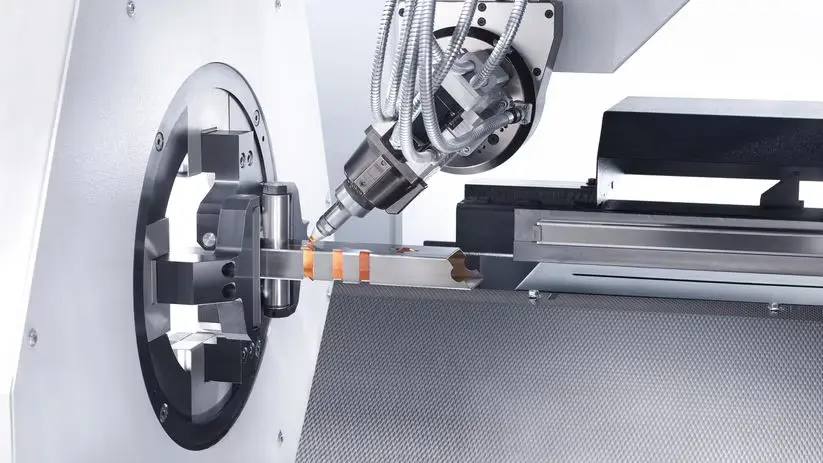 5-axis tube laser cutting head cutting a square aluminum tube with a honeycomb cutting bed behind it