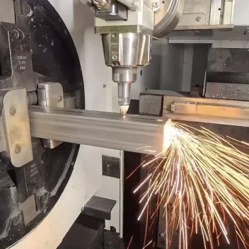 5-axis tube laser cutting an aluminum tube section, throwing sparks